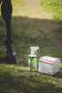 Kerbl Wundspray 500 ml steht neben Absorba Verbandsvlies auf dem Boden in der Natur - daneben ein Pferd.