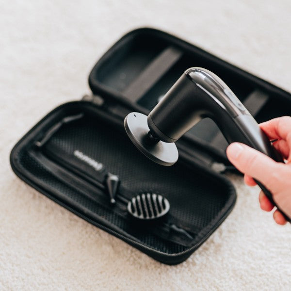 Novafon Reha-Set in Schwarz: kabelloses Schallwellengerät mit aufgestecktem Telleraufsatz XL. Igel- und Kegelaufsatz liegen im Hintergrund in handlicher Tasche, für Massage, Therapie und Schmerzlinderung.
