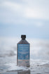 Totes Meer Salzsole 2,5% 1 Liter vor Meereskulisse im Wasser stehend am Strand