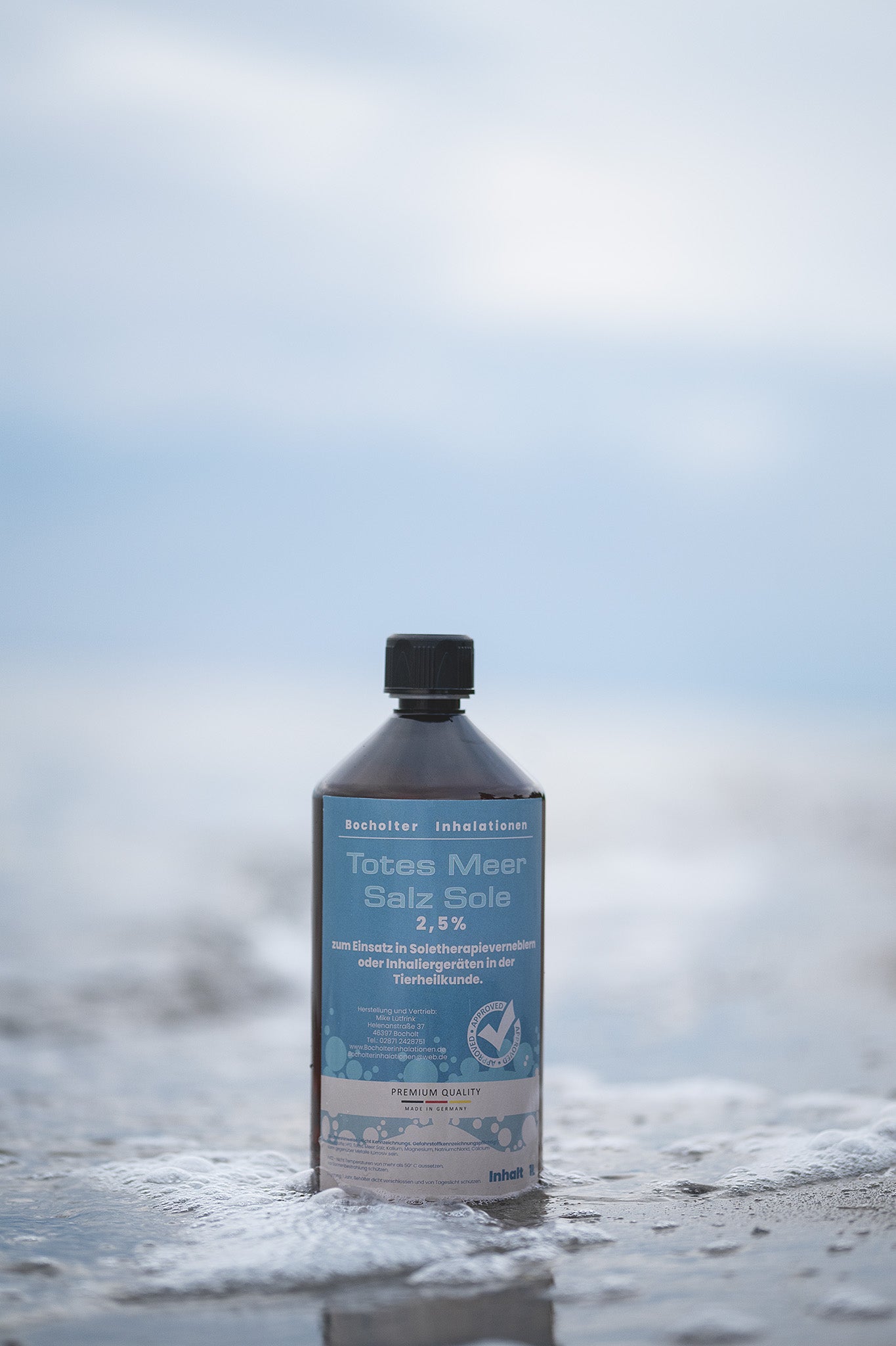 Totes Meersalz Sole 2,5% 1 Liter vor Meereskulisse im Wasser stehend am Strand