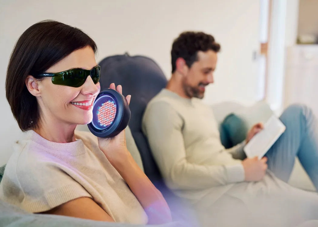 Anwendung der Low-Level-Light-Therapie mit B.Light Clear Evo auf der Gesichtshaut - komfortabel auf dem Sofa sitzend