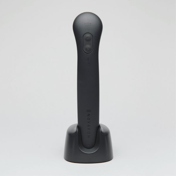 Das Novafon Power in Schwarz steht sicher auf der Ladestation – ideal für intensive Vibrationstherapie