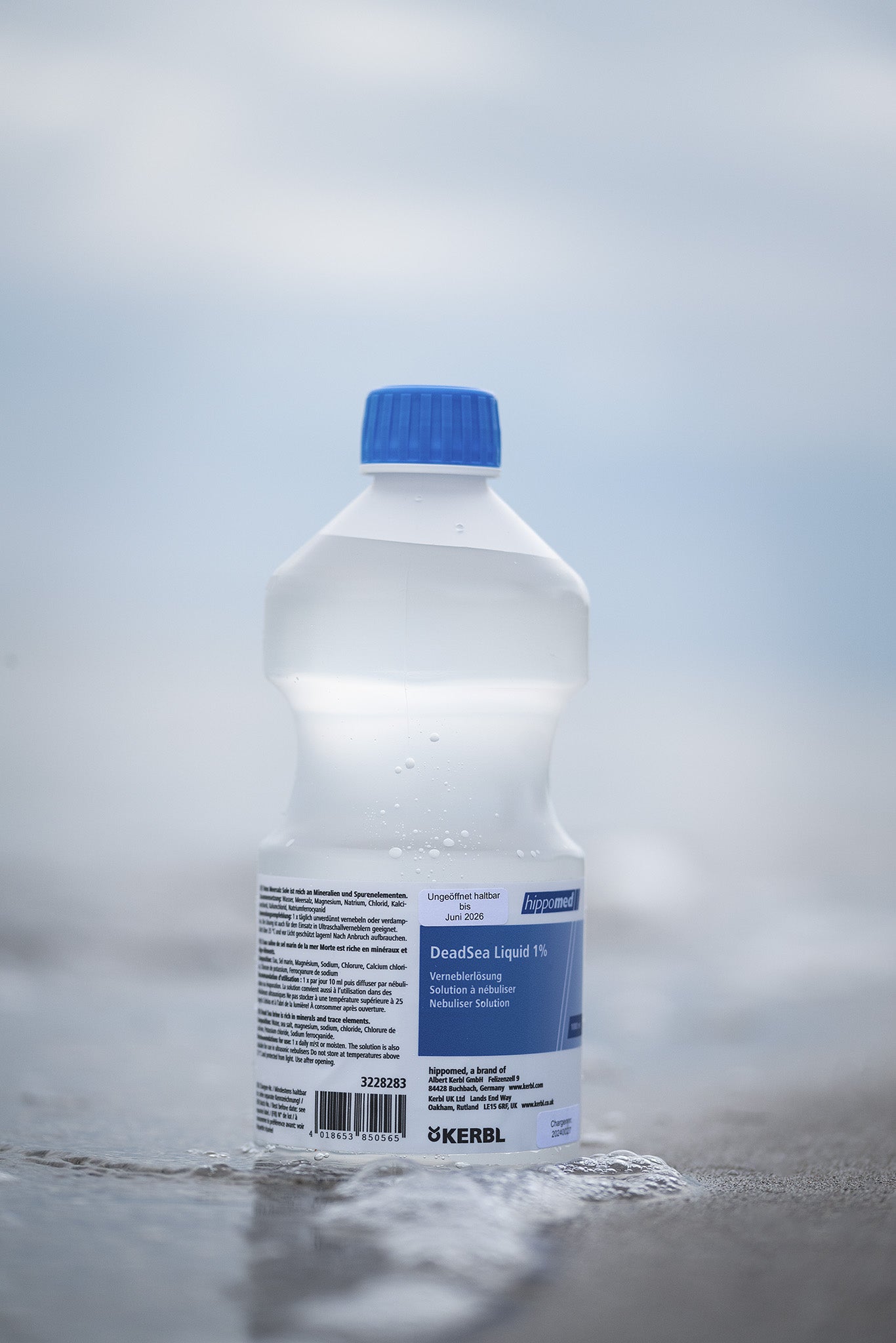 DeadSea Liquid Inhalationslösung mit Totes Meer Salz für Pferde steht in Meereswellen am Strand