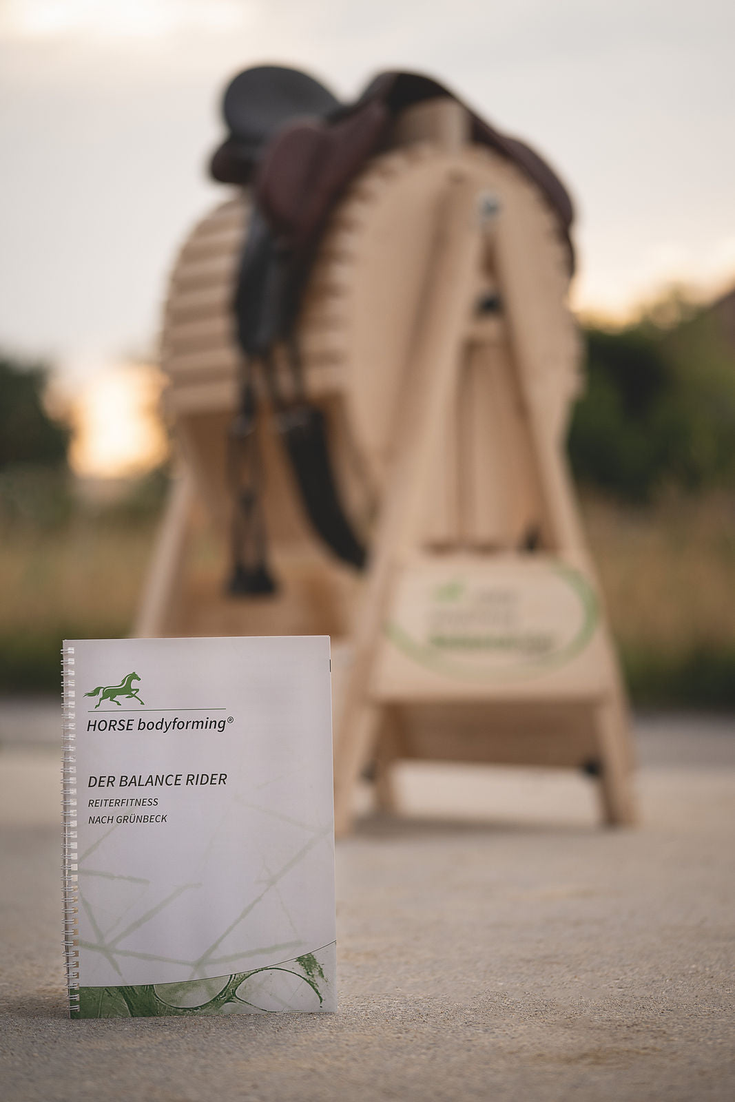 Balance Rider von Horse bodyforming in der Natur im vordergrund das Trainingsbuch mit passenden Übungen für Reiterfitness dazu