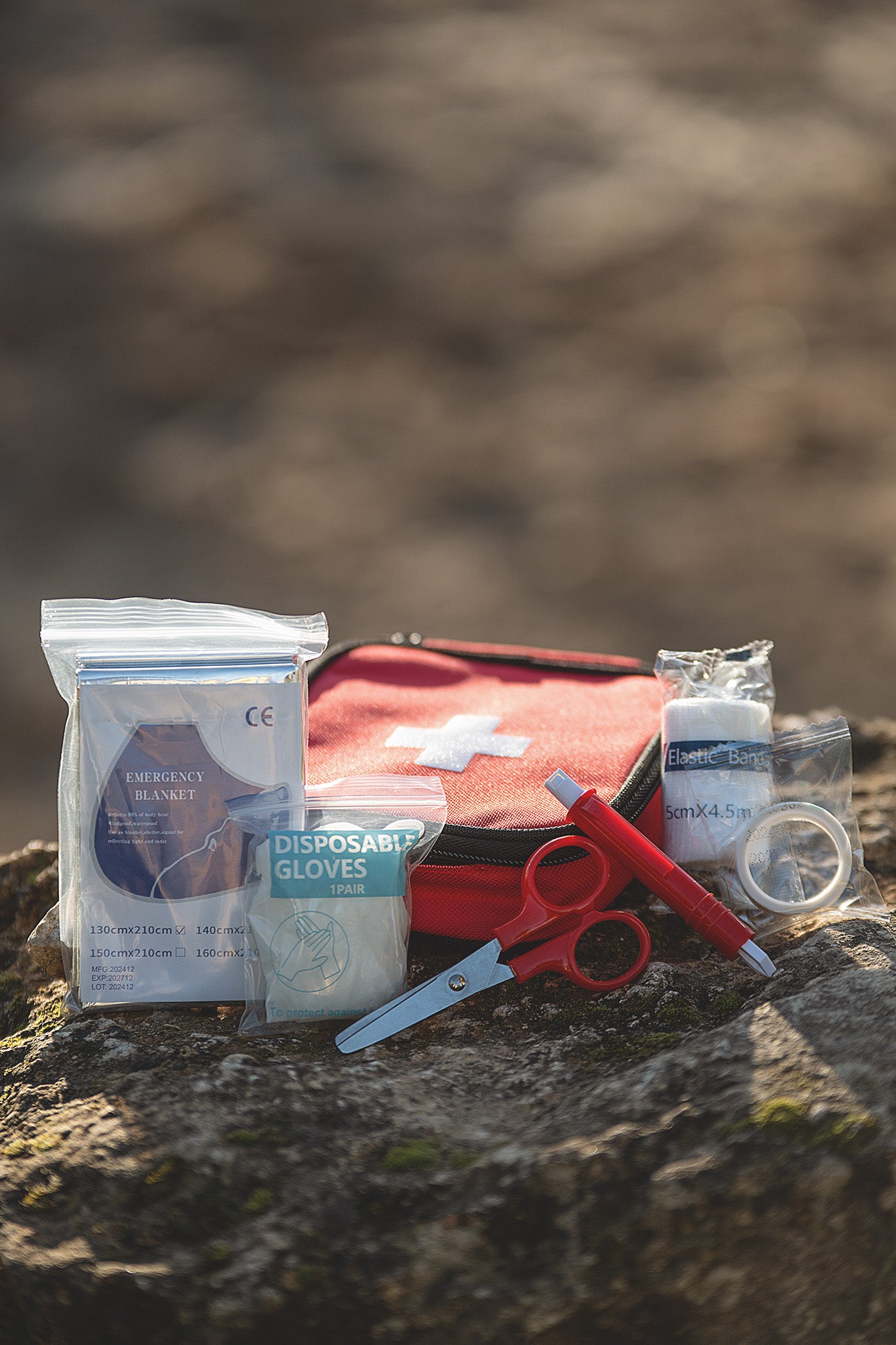 Kerbl Erste Hilfe Set für Hunde und Pferde mit geöffnetem Inhalt auf einem Stein in der Natur