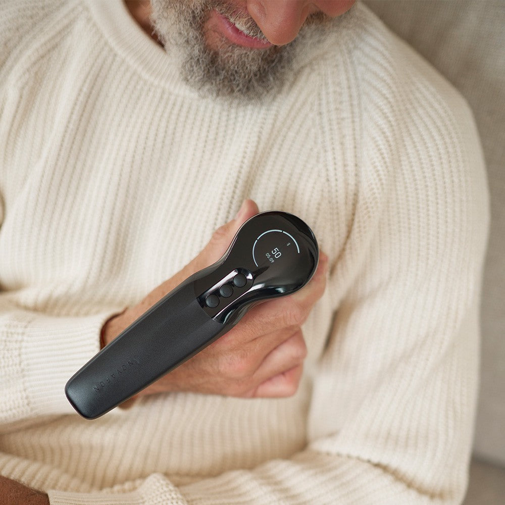 Novafon max+ während der Schallwellentherapie am Brustmuskel eines Mannes - Wirkung durch Kleidung hindurch