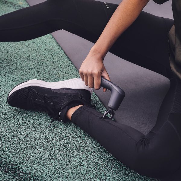 Novafon Physio-Set – Anthrazitfarbene Fasziengabel bei der Wadenbehandlung durch Textil hindurch