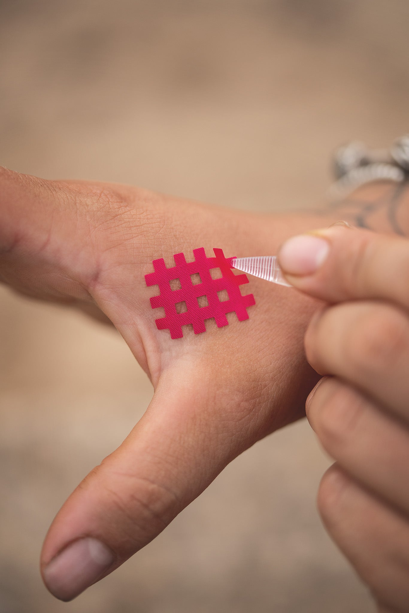 Pinzette für Gittertapes bei der präzisen Anwendung auf der Haut