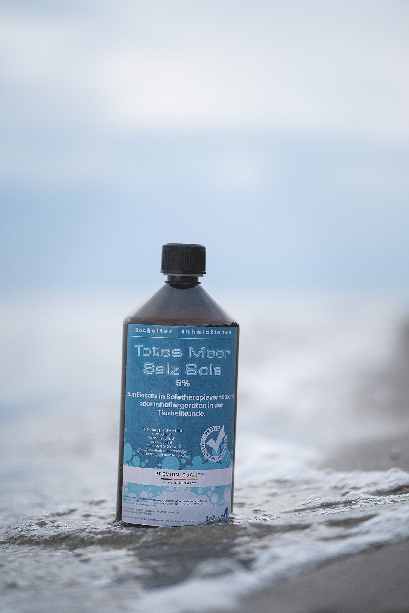 Totes Meer Salzsole 5% naturrein und ohne Zusatzstoffe - Flasche vor Meereskulisse im Wasser stehend